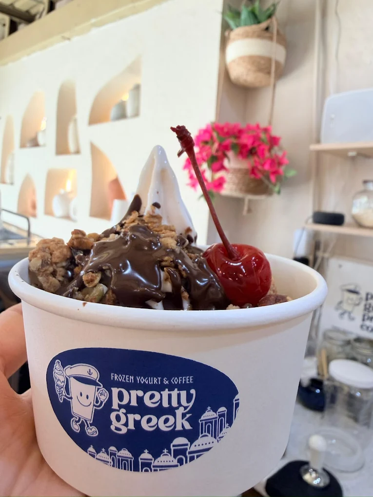 Copa de frozen yogurt con granola, nuez, cereza y chocolate